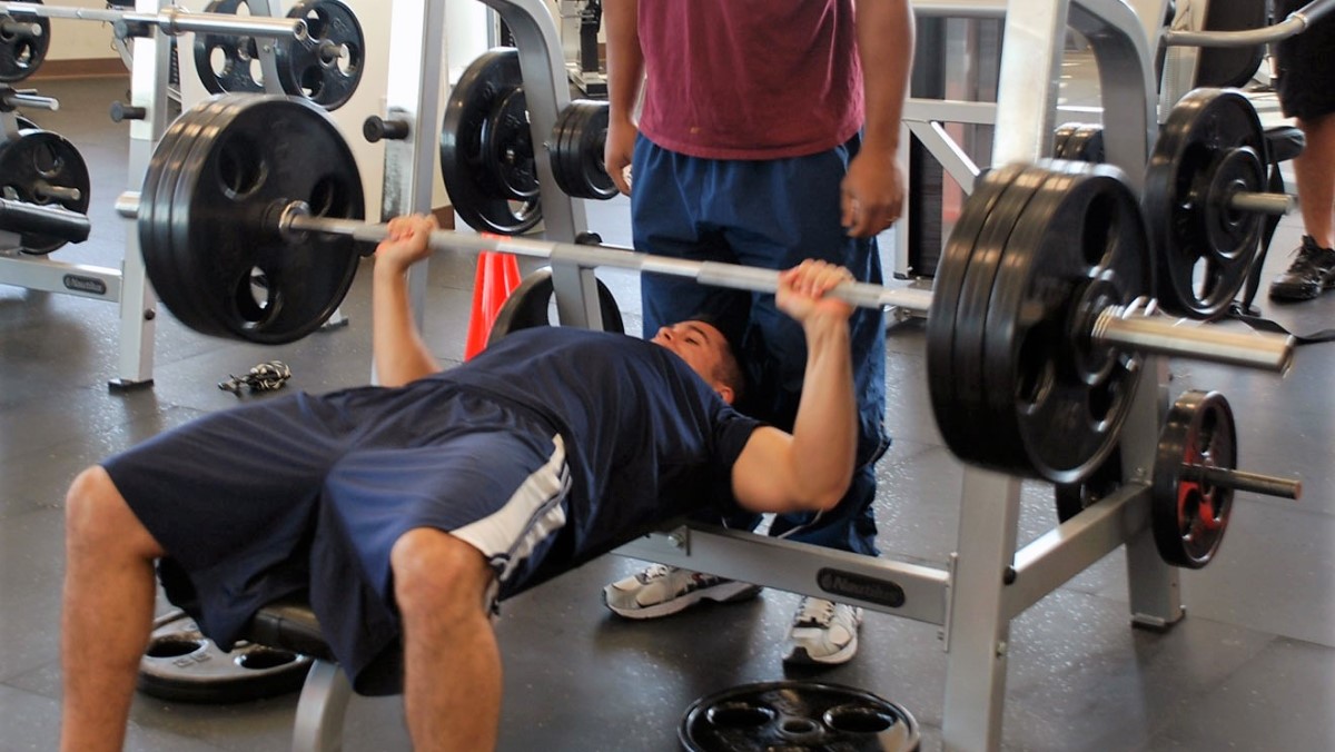 Exactly how much does the bench press bar weigh? Learn the standard weights for Olympic and other gym barbells.